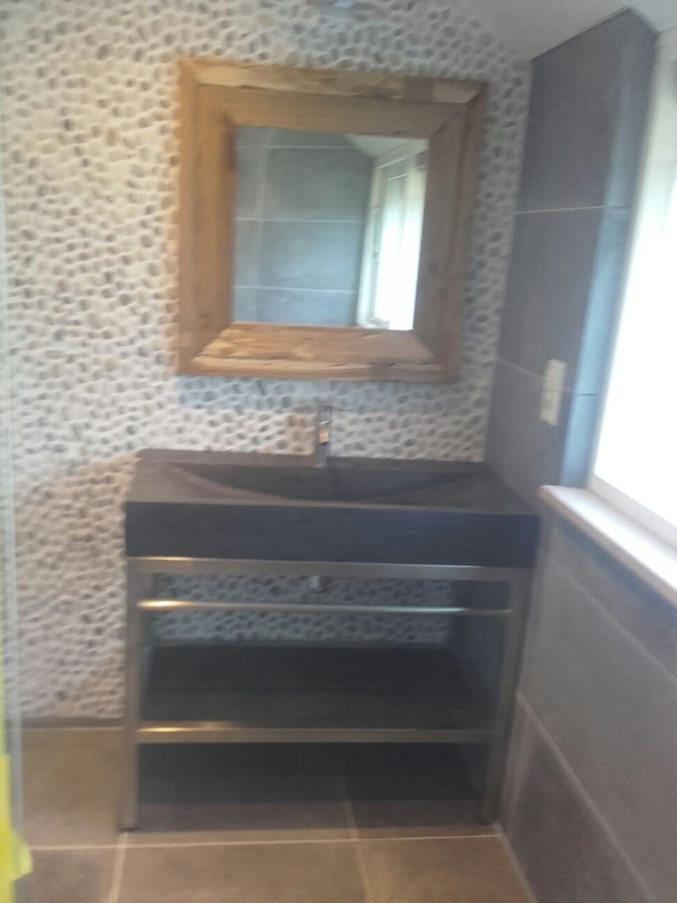 Badkamer met kiezelwand