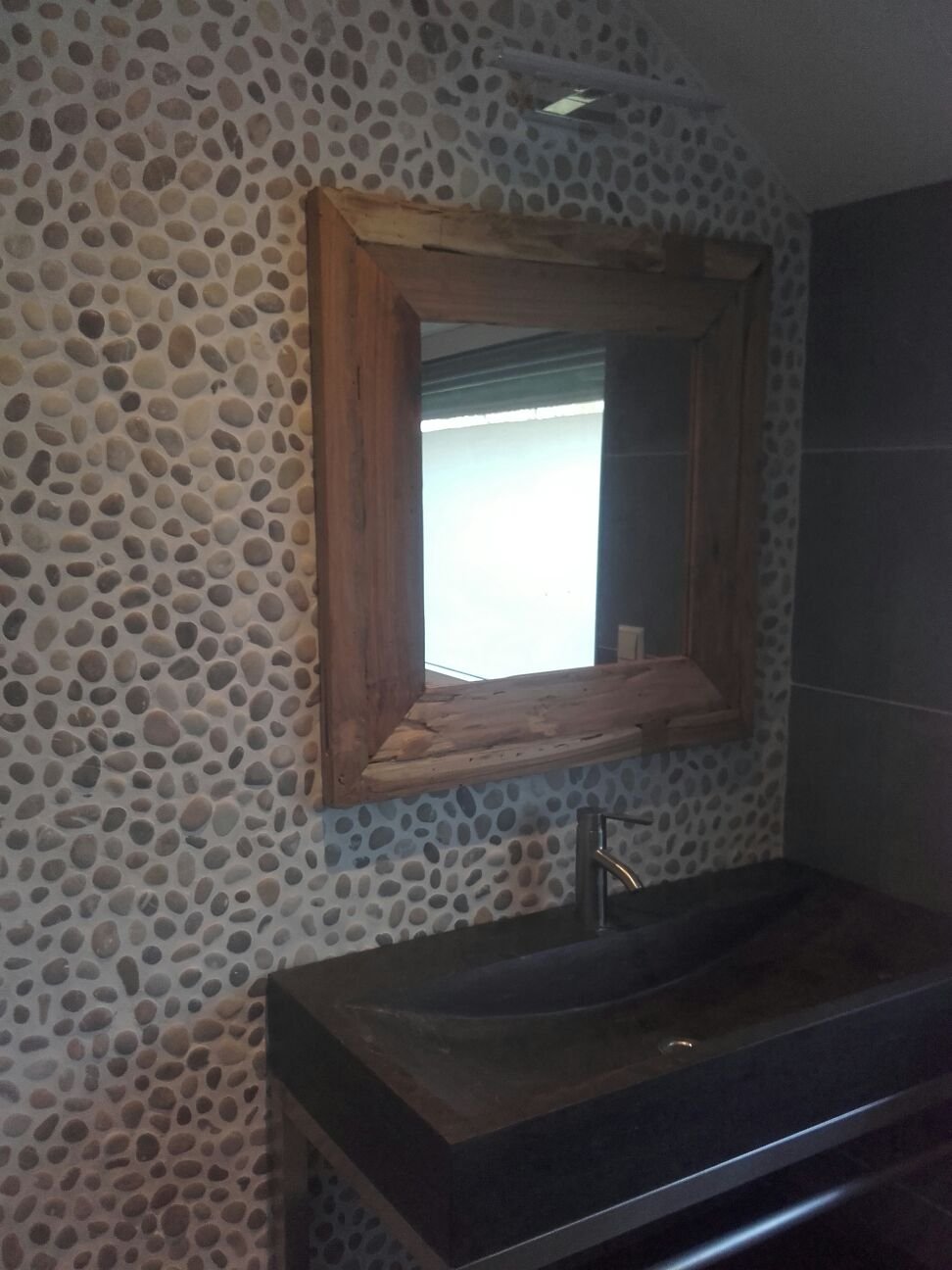 Badkamer met kiezelwand